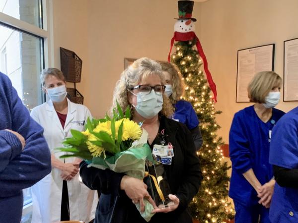 Nurse receiving an award and flowers
