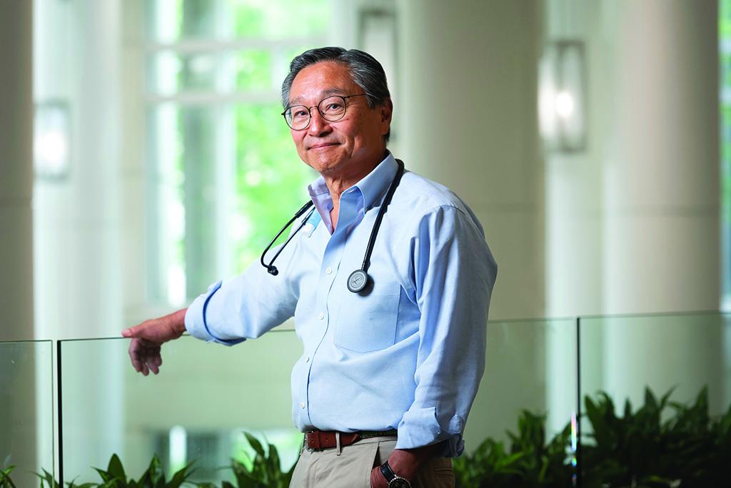 Nelson Chao, MD, leaning on a glass wall