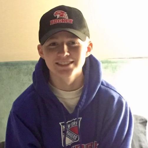 a boy in a baseball cap and hoodie 