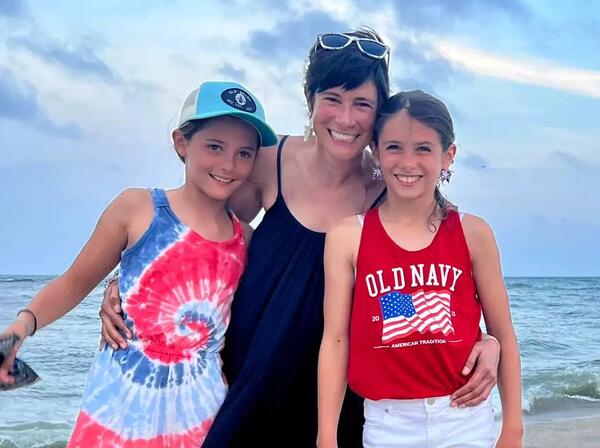 Renee Herman Garber smiling on the beach with her children. 