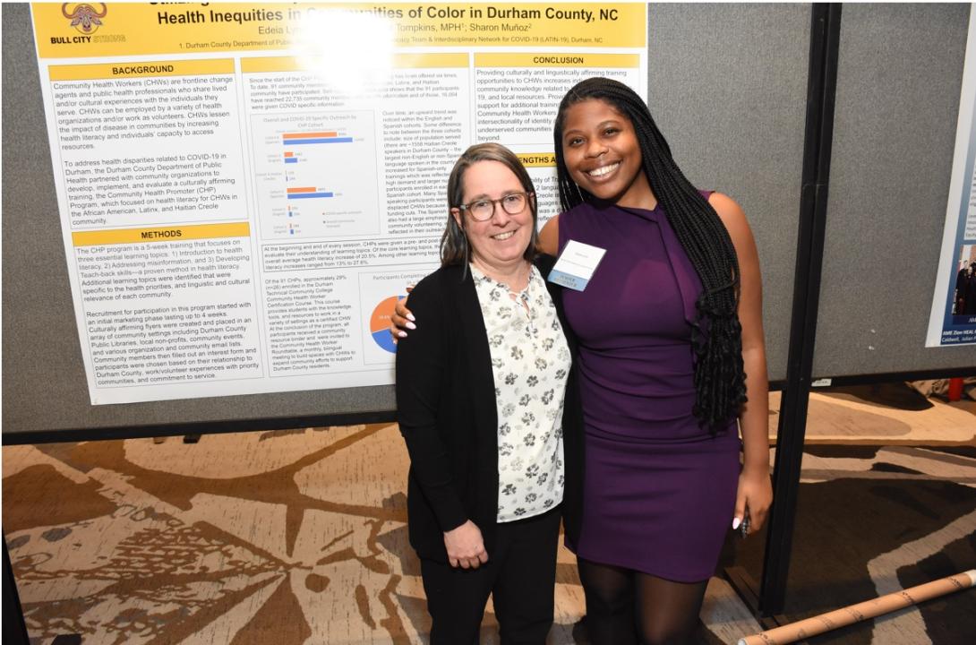 Sally Wilson and Edeia Lynch poses with colleague in front of a poster presentation by the Durham County Department of Public Health 